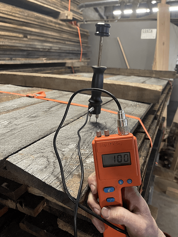 A worker calculating moisture content of wood