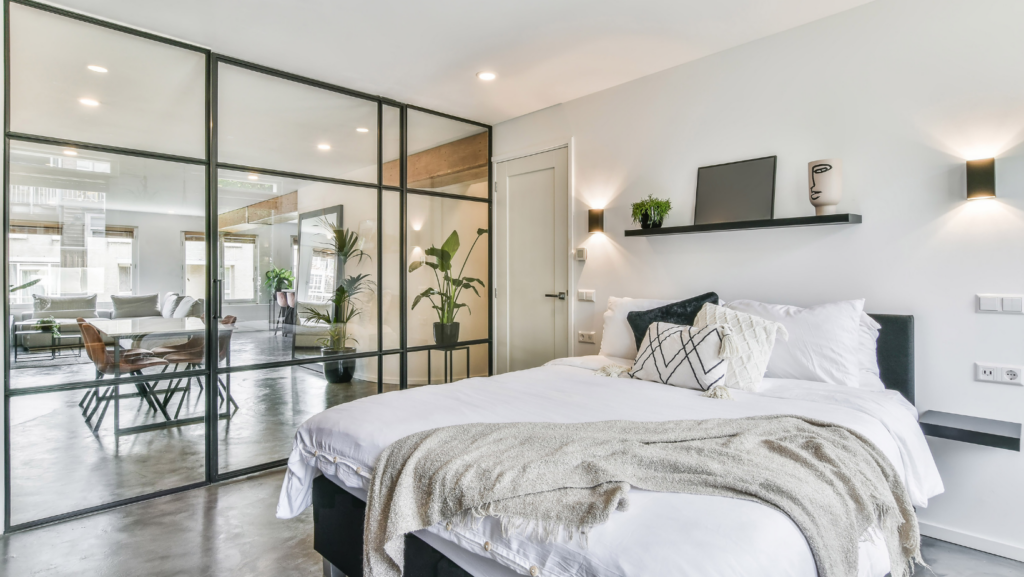 A stunning mirror of a closet in a minimalistic bedroom that has a lot of natural lightening