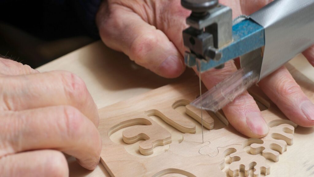 a man using a scroll saw to shape words