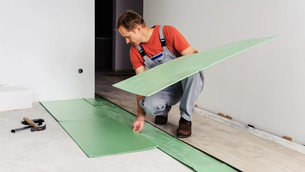 a man preparing wood floor underlayment