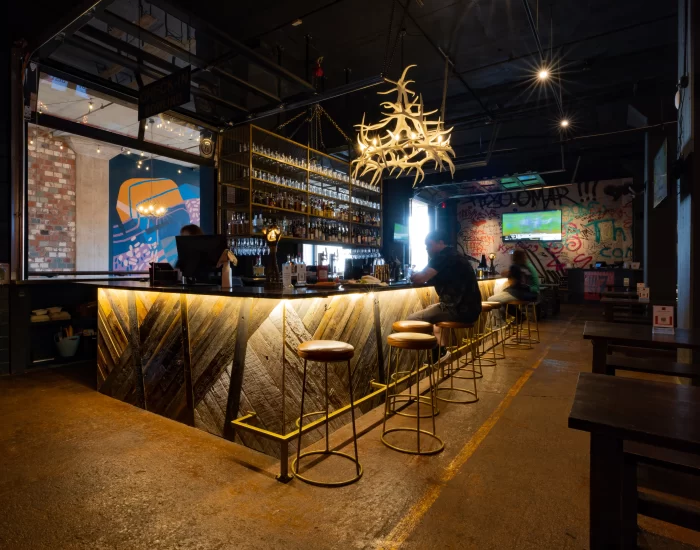 The interior of a restaurant with a bar and stools.