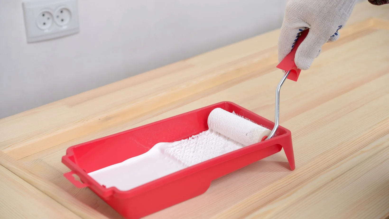 A person preparing to paint a door with white paint