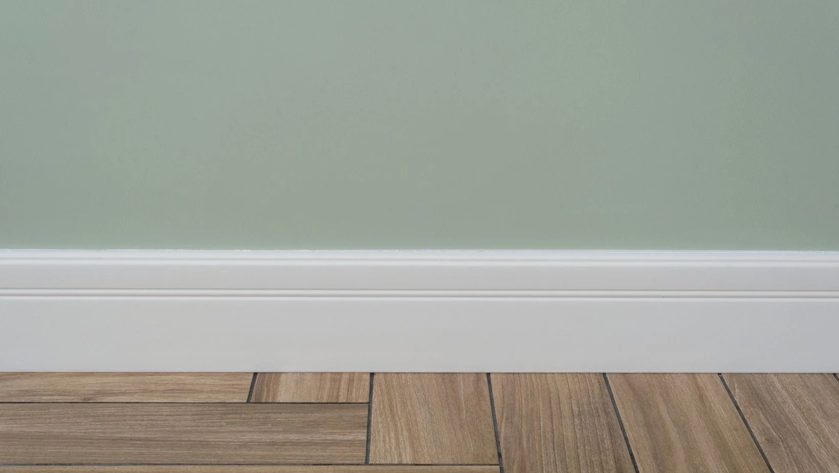 Light Green Matte Wall and a White Baseboard